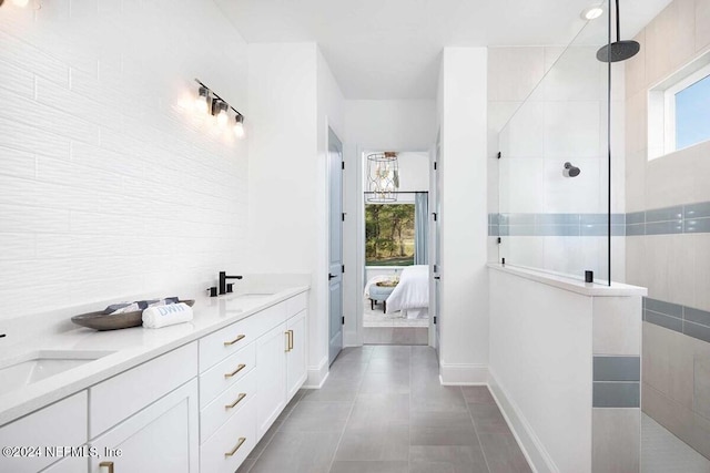 bathroom with tile walls, vanity, tile patterned floors, and tiled shower