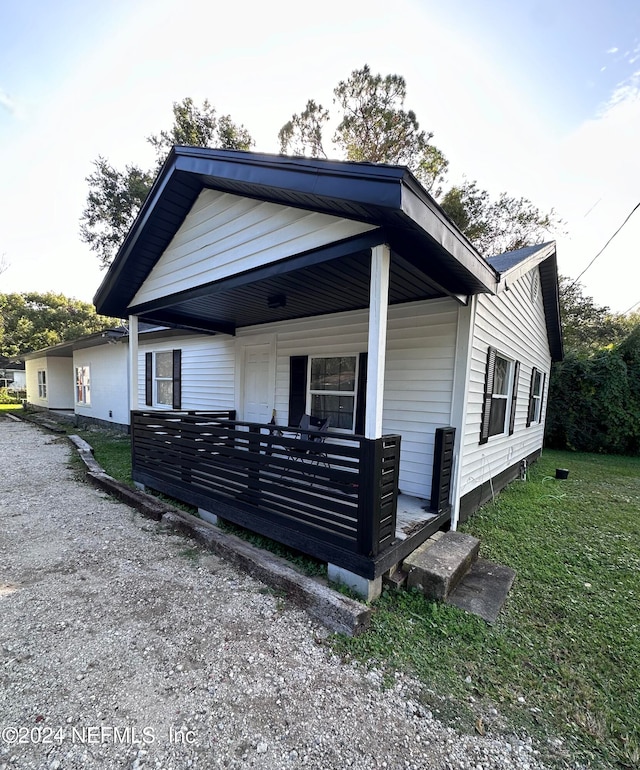 view of front of property featuring covered porch and a front yard