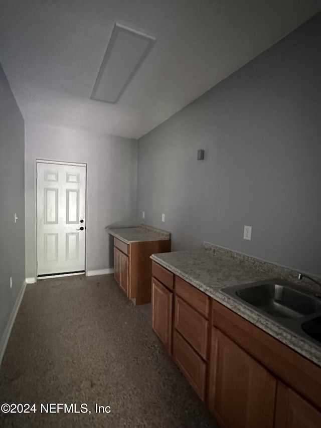 2122 Ashland St, Jacksonville, FL 32207 - kitchen with brown cabinets, baseboards, a sink, and light countertops