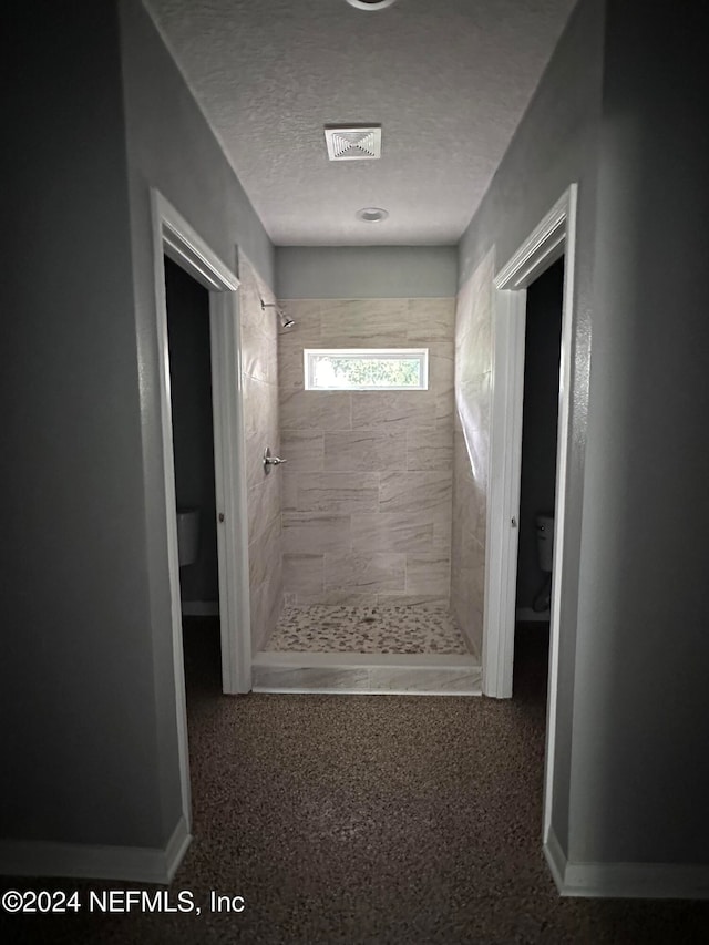 corridor with carpet floors and a textured ceiling