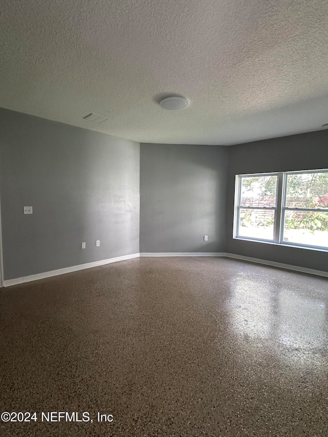 unfurnished room featuring a textured ceiling