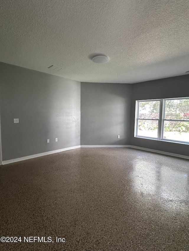 2122 Ashland St, Jacksonville, FL 32207 - empty room featuring a textured ceiling, baseboards, and speckle patterned floor