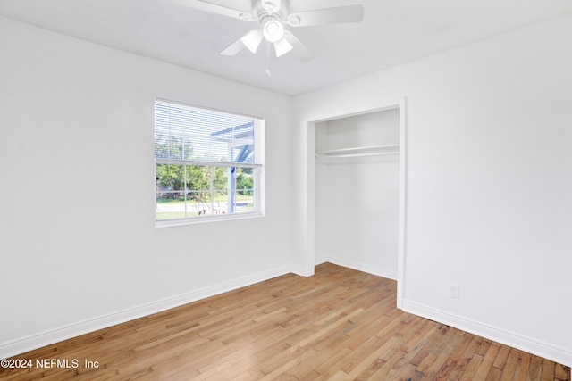 unfurnished bedroom with ceiling fan, a closet, and light wood-type flooring