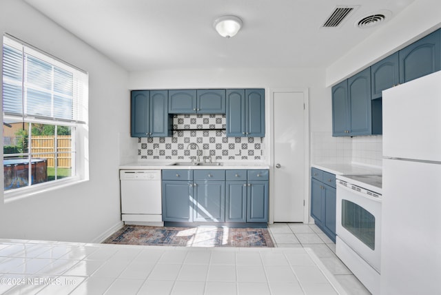 kitchen featuring sink, white appliances, light tile patterned floors, and decorative backsplash