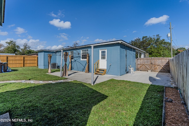 rear view of house with central air condition unit, a yard, and a patio