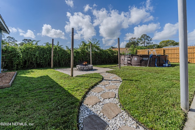 view of yard featuring a fire pit and a patio area