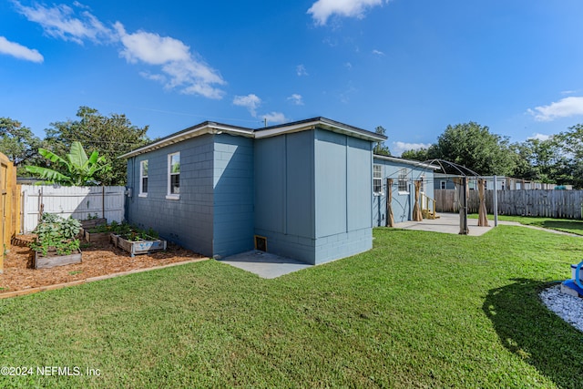 rear view of property with a lawn and a patio area