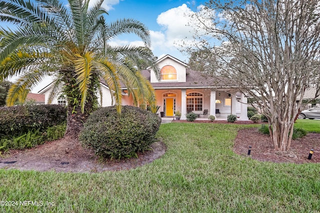 view of front facade with covered porch and a front yard