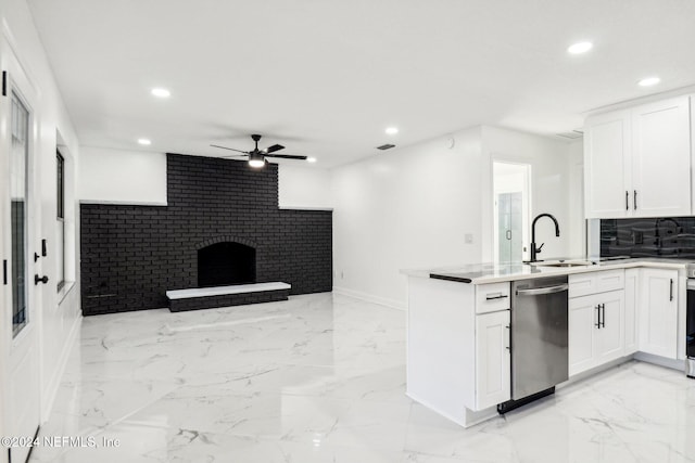 kitchen featuring stainless steel dishwasher, white cabinets, sink, and kitchen peninsula