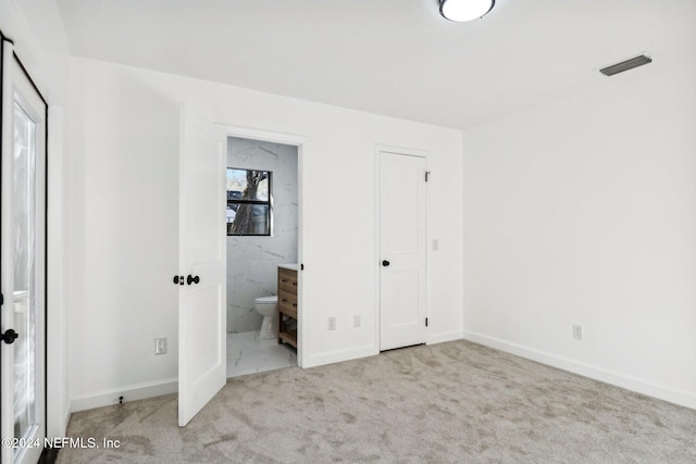 unfurnished bedroom featuring ensuite bath and light carpet