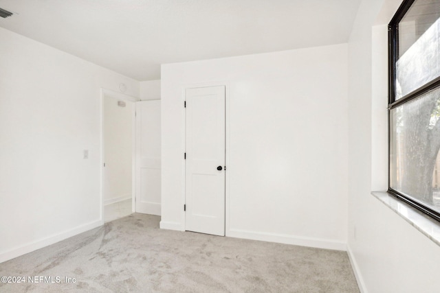 unfurnished room featuring light colored carpet