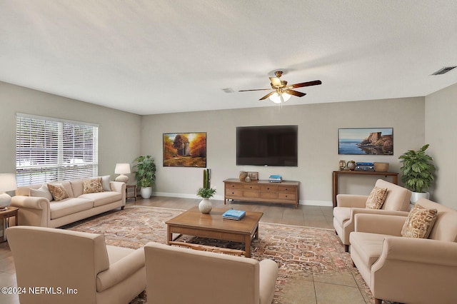 living room featuring a textured ceiling, ceiling fan, and light tile patterned flooring