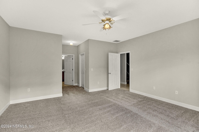 spare room with ceiling fan and carpet