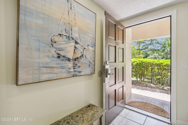 foyer with a textured ceiling and light tile patterned floors