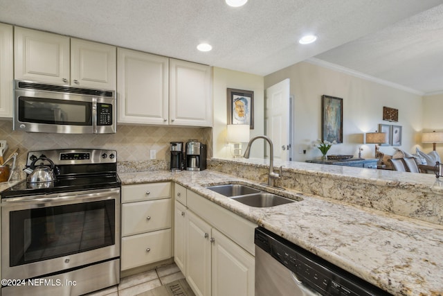 kitchen with decorative backsplash, appliances with stainless steel finishes, sink, and crown molding