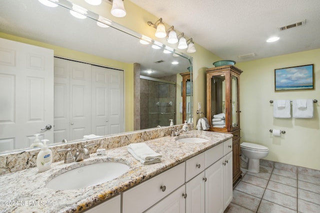 bathroom featuring vanity, a textured ceiling, an enclosed shower, tile patterned flooring, and toilet