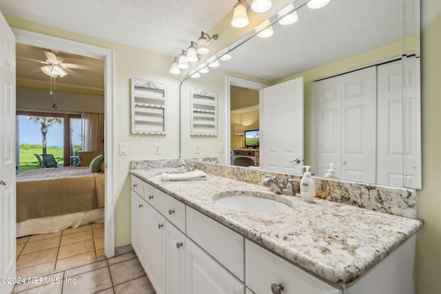 bathroom with vanity, tile patterned flooring, a textured ceiling, and ceiling fan