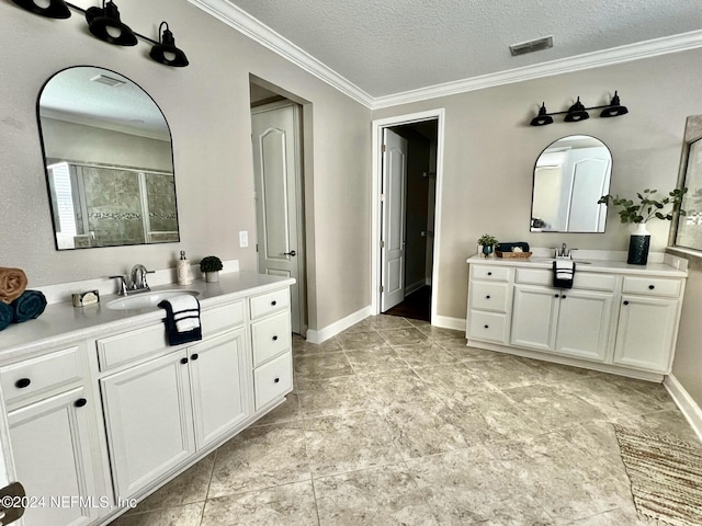 bathroom with a textured ceiling, vanity, crown molding, and walk in shower