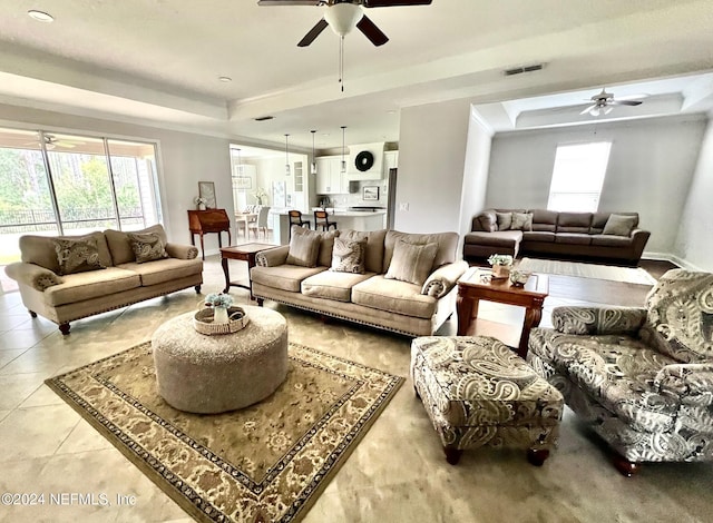 living room with light tile patterned floors and a raised ceiling