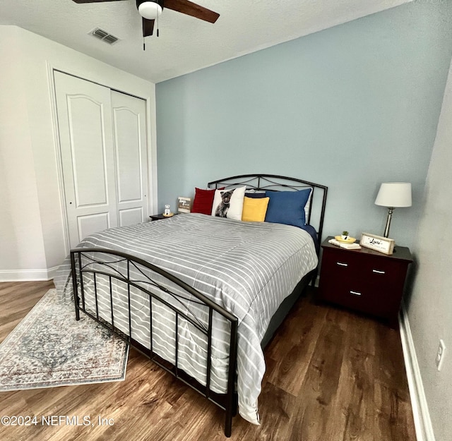 bedroom featuring a closet, dark wood-type flooring, and ceiling fan