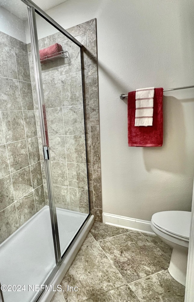 bathroom with toilet and an enclosed shower