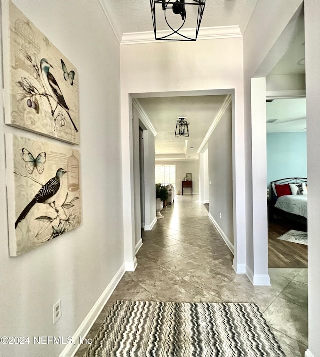 hall featuring a notable chandelier and ornamental molding