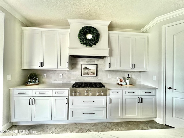 bar with backsplash, custom exhaust hood, crown molding, white cabinets, and stainless steel gas stovetop