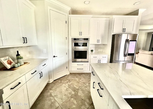 kitchen with white cabinets, light stone countertops, and stainless steel appliances