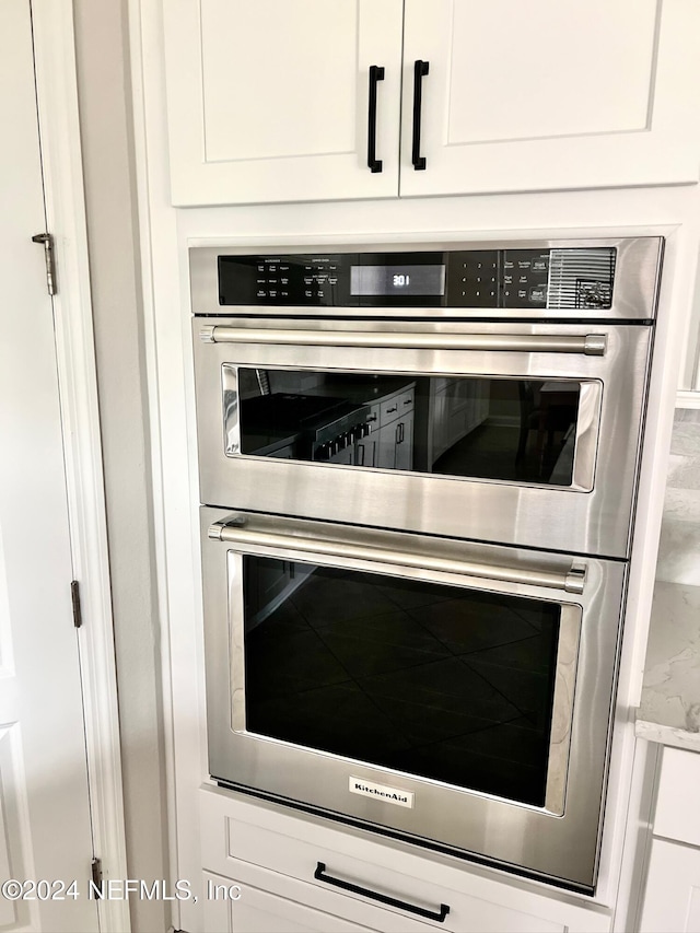 interior details with white cabinetry and double oven