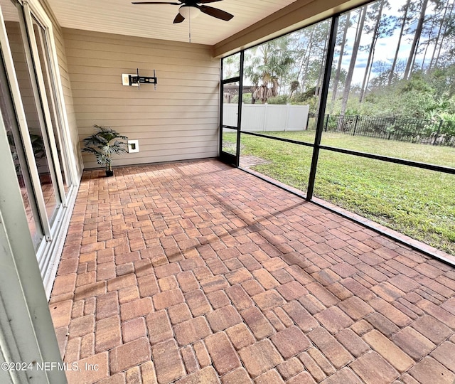 unfurnished sunroom with ceiling fan