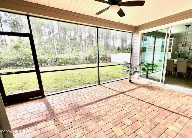 unfurnished sunroom featuring ceiling fan