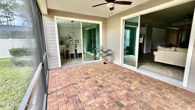 unfurnished sunroom with ceiling fan and plenty of natural light