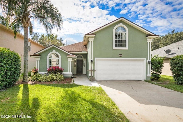 view of property featuring a garage and a front lawn