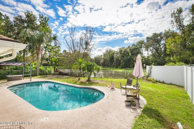 view of swimming pool with a lawn and a patio area