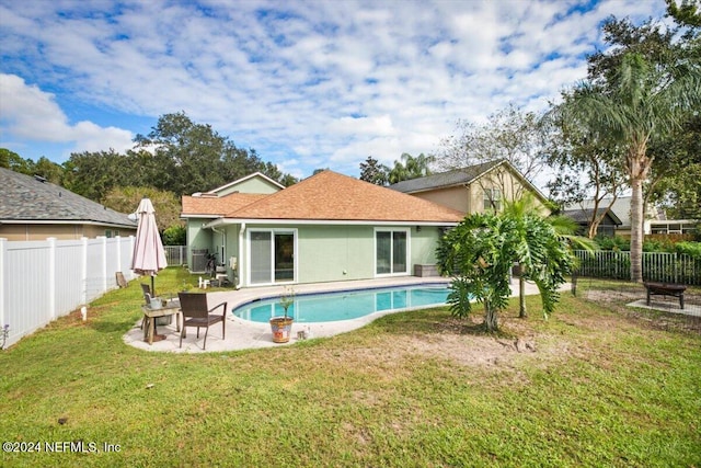 back of house with a patio, a fenced in pool, and a lawn