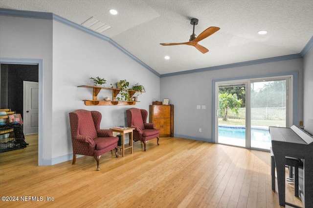 sitting room with ornamental molding, a textured ceiling, vaulted ceiling, ceiling fan, and light hardwood / wood-style floors