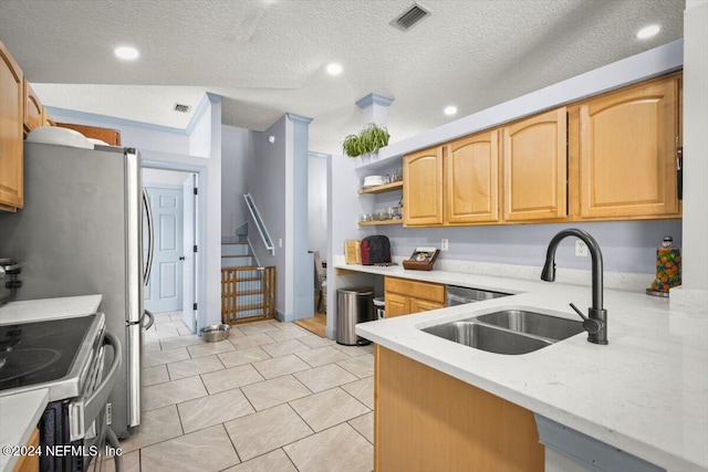 kitchen with sink, stove, a textured ceiling, and light brown cabinets