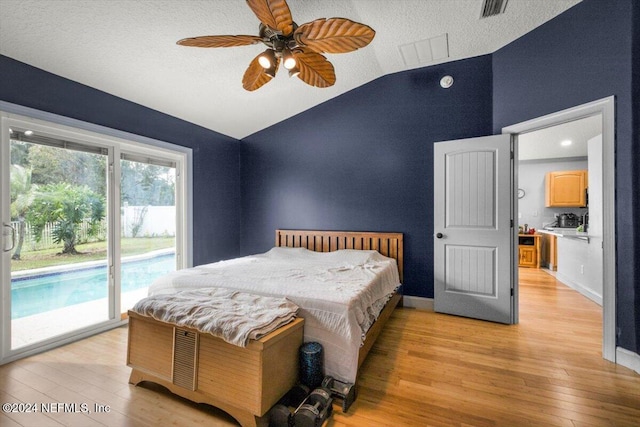 bedroom featuring access to exterior, ceiling fan, light hardwood / wood-style floors, a textured ceiling, and vaulted ceiling