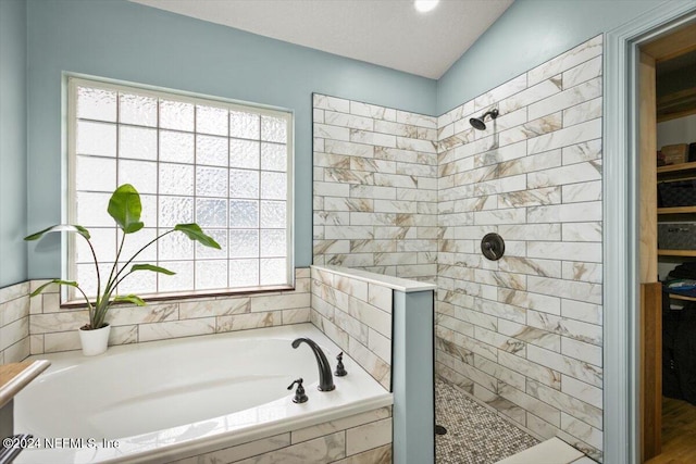 bathroom featuring shower with separate bathtub