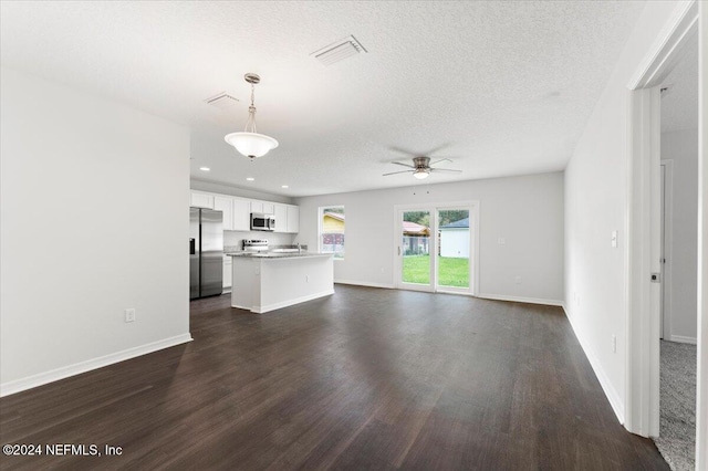 unfurnished living room with dark wood-type flooring, a textured ceiling, and ceiling fan