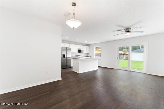 unfurnished living room featuring a textured ceiling, dark wood-type flooring, and ceiling fan