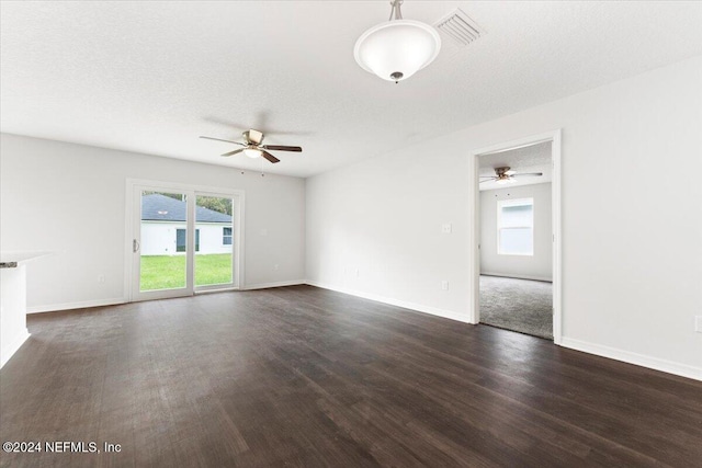 spare room featuring dark hardwood / wood-style flooring, a textured ceiling, and ceiling fan