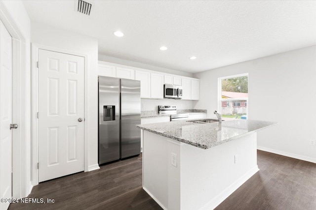 kitchen featuring white cabinets, an island with sink, dark hardwood / wood-style floors, light stone countertops, and appliances with stainless steel finishes