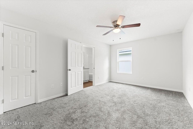 unfurnished bedroom with a textured ceiling, carpet floors, and ceiling fan