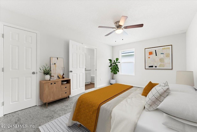 bedroom featuring ceiling fan, connected bathroom, a textured ceiling, and carpet