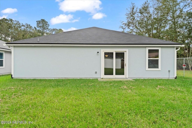 rear view of property with a yard