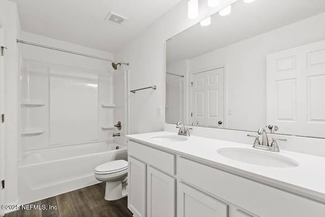 full bathroom with wood-type flooring, toilet, vanity, and shower / bathing tub combination