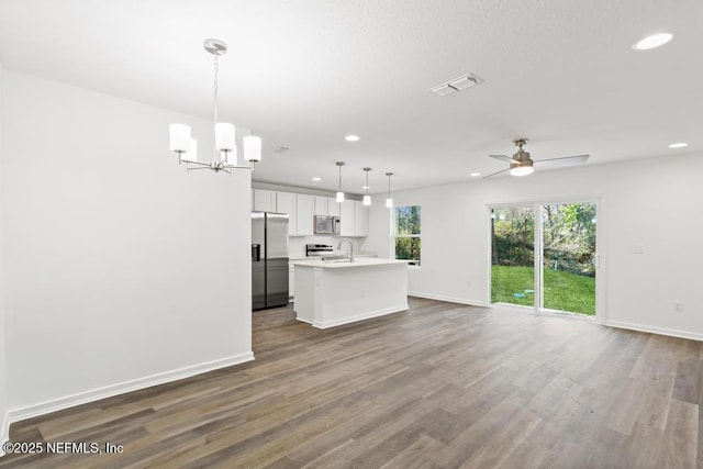 kitchen with pendant lighting, white cabinetry, sink, a kitchen island with sink, and stainless steel appliances