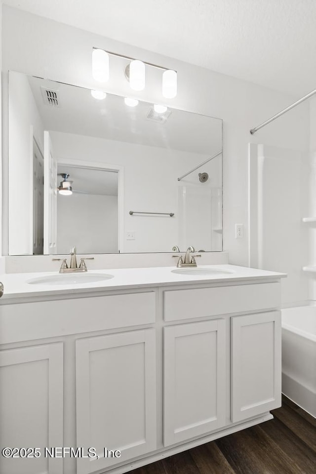 bathroom featuring shower / bathtub combination, vanity, and hardwood / wood-style floors