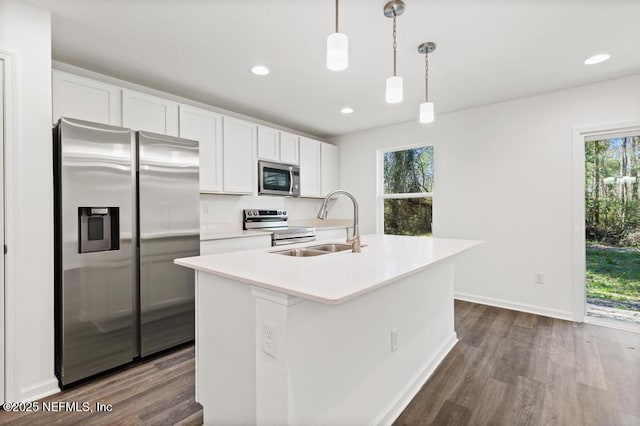 kitchen featuring appliances with stainless steel finishes, a kitchen island with sink, and white cabinets